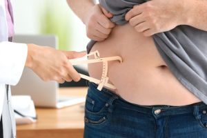 Personne obèse rencontre un médecin pour savoir quelle chirurgie pratiquer : bypass ou sleeve